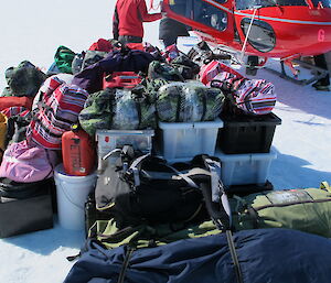 bags full of rock samples and containers with field equipment in a depot on the ice awaiting pick up.