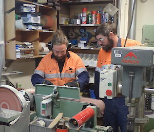 Expeditioners using a sander in a workshop