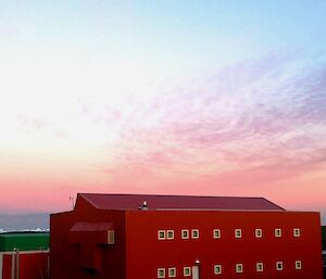 Sunrise sky above a large red accommodation module