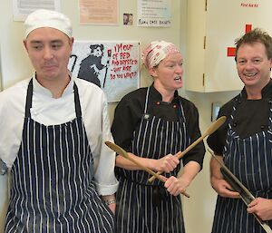 Three chefs, one female and two male, goofing around in the kitchen at Davis station