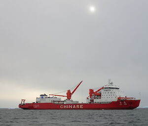 Red and white Chinese resupply ship anchored at sea