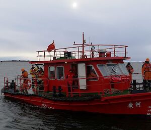 Brightly painted CHINARE work boat docking at Davis wharf