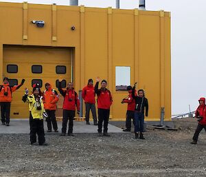 Visting CHINARE expeditioners facing camera smiling whilst on a tour of Davis station