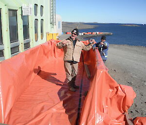 Expeditioners lining a disposal container facing camera
