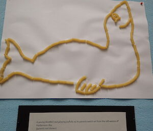 Macaroni glued onto white paper in the form of a seal