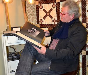 Expeditioner reading a book in the station library prior to an art exhibition