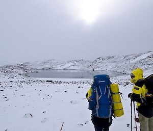 Two expeditioners walking towards a lake