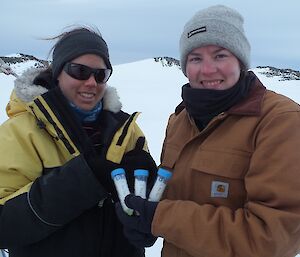 Two expeditioners holding water samples