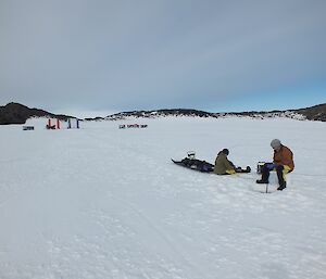 Two expeditioners undertaking lake sampling sitting on sea ice