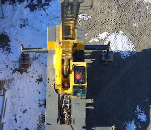 Plant operator sitting inside the cab of a crane looking up at camera