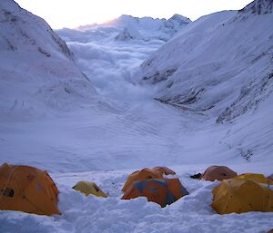 Tents at the base of a mountain range in the Himalayas