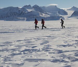 Man running an Antarctic marathon with two others
