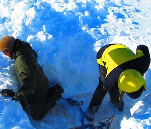 Expeditioners excavating science equipment from an ice shelf