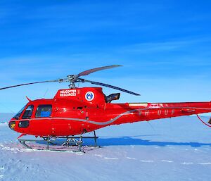 Red helicopter in foreground. Scientific instruments on ice shelf in background