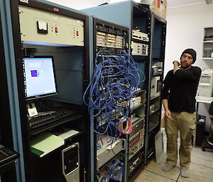 Man standing next to a computer data rack