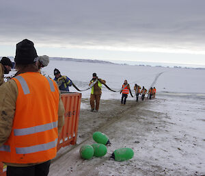 Expeditioners load a fuel hose into a 20ft half height container