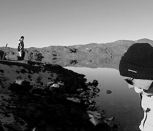 Two expeditioners amidst rocky terrain looking away from camera