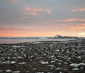 Sunrise at Davis, red flecked clouds above dark rocky and snow covered terrain