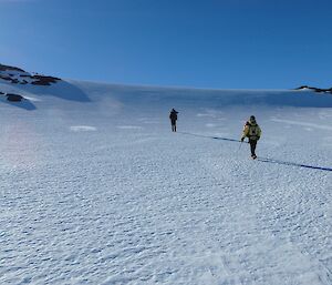 Expeditioners walking through a snow filled gully