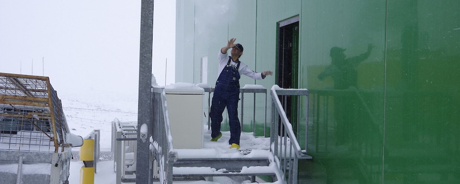 Expeditioner throwing a snowball from off the back of the living quarters