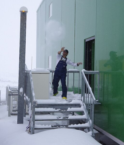 Expeditioner throwing a snowball from off the back of the living quarters
