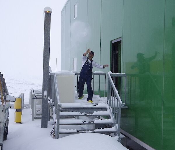 Expeditioner throwing a snowball from off the back of the living quarters