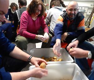 Group of expeditioners huddled around the boxes of potatoes