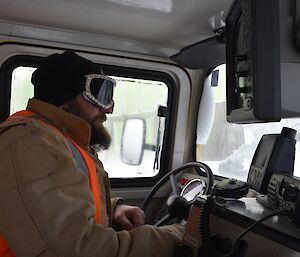 Expeditioner sitting in the drivers cab of a hagg tracked vehicle