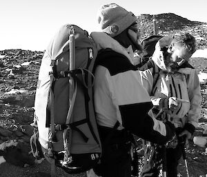 Two expeditioners stand away from camera looking at a map