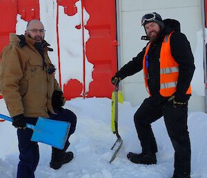 Two expeditioners digging out temporary accommodation building