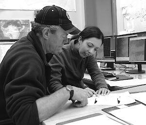 Expeditioners consulting weather prior to flying operations