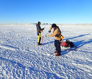 Expeditioner drilling through sea ice with a manual drill