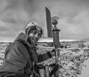 Expeditioner perched on a tower in safety equipment