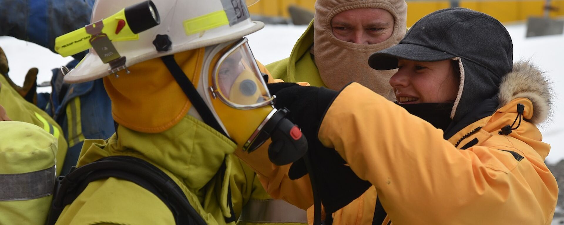 Expeditioner assists another with breathing apparatus during a fire drill