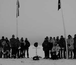 Expeditioners gathered beneath a flag pole after the Anzac day dawn service