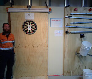 Expeditioner standing in front of his novelty dartboard