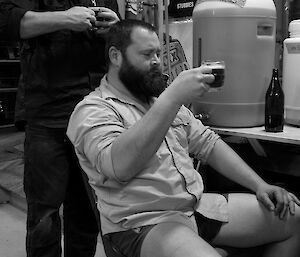 Expeditioner examining a poured bottle of beer in a basement