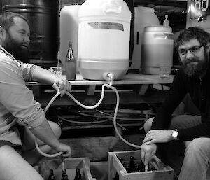 Expeditioners filling beer bottles in a basement