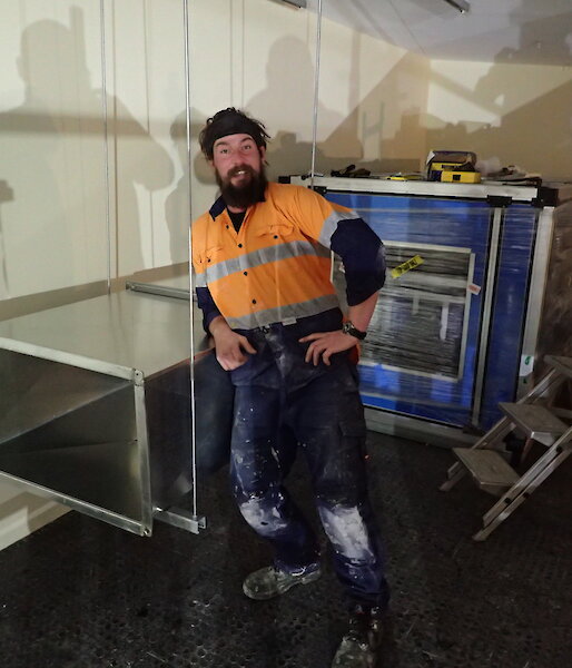 expeditioner photographed standing beside ducting