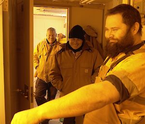 three expeditioners standing towards camera in hydroponics shed