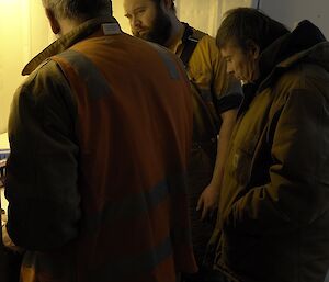 Three expeditioners review their work in the hydroponics unit