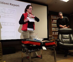 Expeditioner standing in front of a powerpoint presenting a lecture on medical emergency response