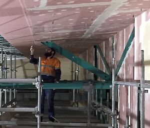 Expeditioner installing plaster sheets