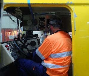 Expeditioner working on wirigin systems in tracked vehicle within the diesel workshop