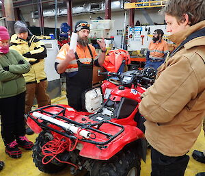 Expeditioners standing around a quad bike being instructed on fault finding