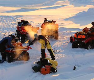 Expeditioners trying to start quads in below freezing conditions