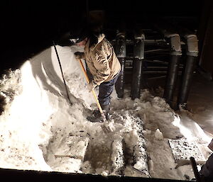 expeditioner digging out a pipeline with a shovel in the darkness
