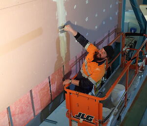 Expeditioner on an elevated work platform plastering