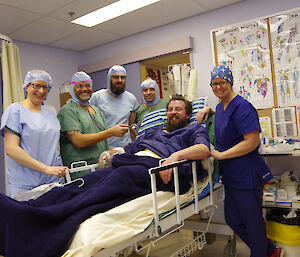 Members of the lay surgical team in surgical gowns in the theatre practising procedures