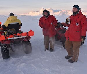 Three expeditioners beside quads chatting